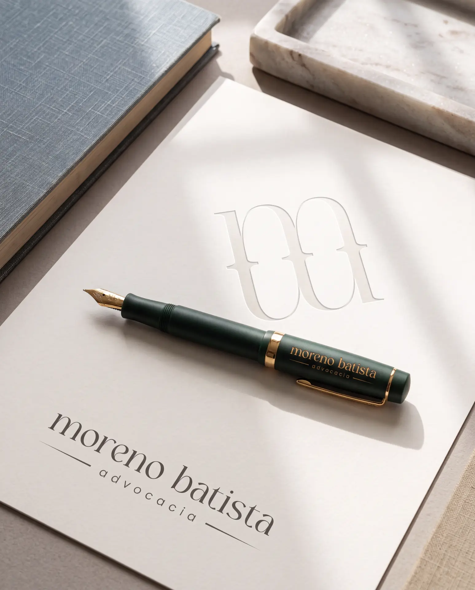 Caneta tinteiro verde com logotipo dourado sobre papel timbrado